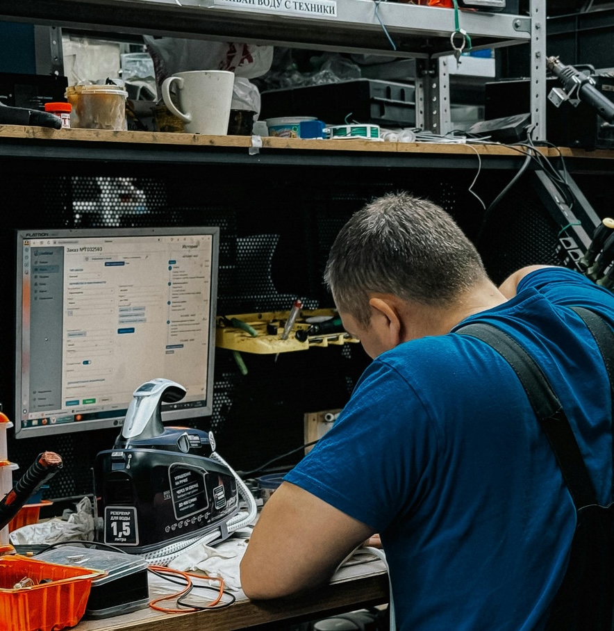 canva repair technician working at desk in workshop mag4wskltra